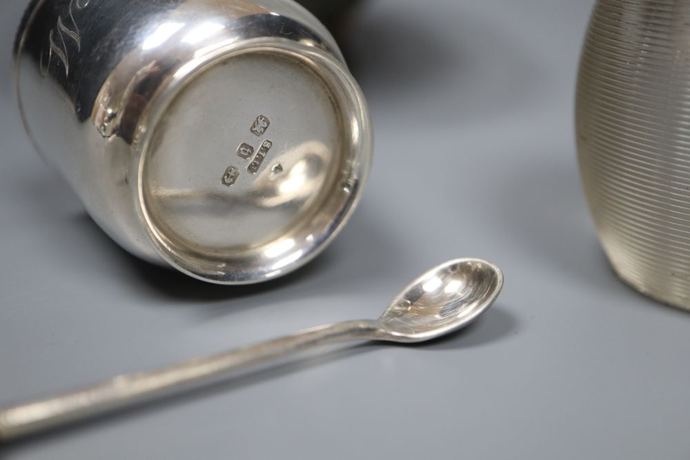 An Edwardian silver sugar basket, George V silver bon-bon dish, silver mounted match strike and a mug salt and spoon (4)